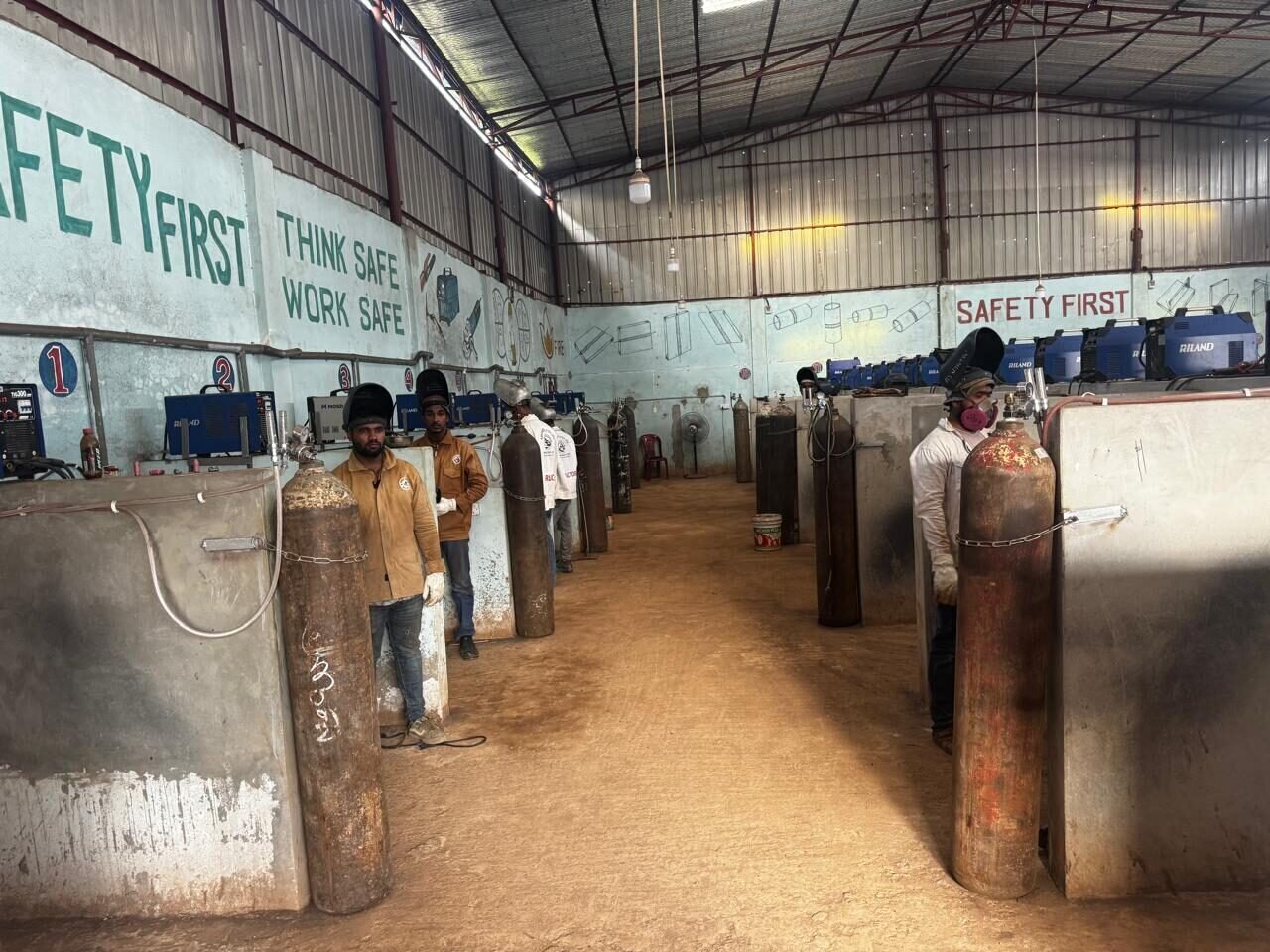 Welding training workshop environment with safety-focused workstations